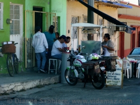 The postal delivery man and others eating breakfast street side